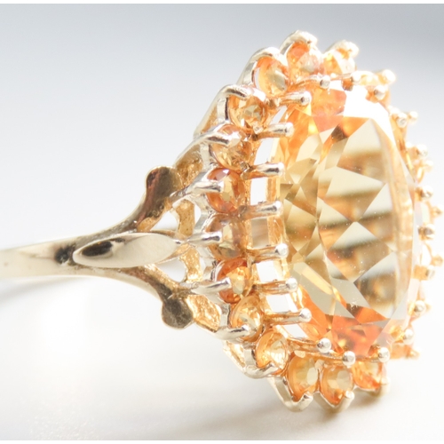 155 - Oval Cut Citrine Set Ring with Further Citrine Set Halo Mounted in 9 Carat Yellow Gold Ring Size O