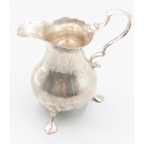 187 - Silver Shaped Form Cream Jug Flying C Scroll Handle Above Shaped Supports 9cm High