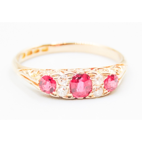 41 - Finely Detailed Ruby Three Stone Ring with Diamond Inset Mounted in 18 Carat Yellow Gold Ring Size O