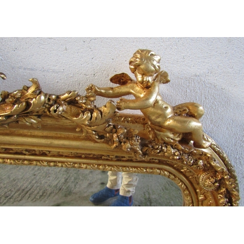 1718 - Gilded Mirror with Upper Cherub Motif Decoration Approximately 56 Inches Wide x 36 Inches High