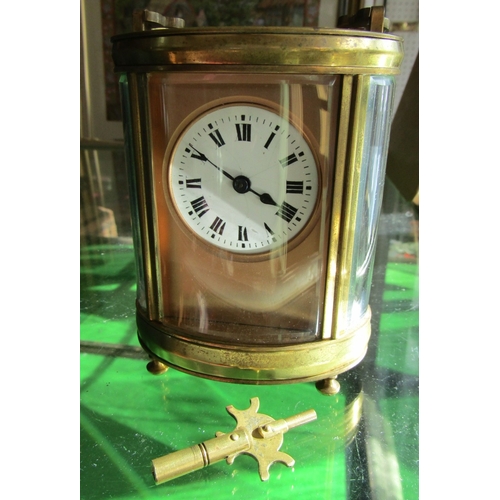 1122 - Oval Form Brass Bound Carriage Clock with Key Attractively Detailed Approximately 5 Inches High