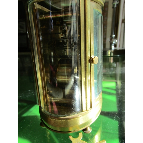 1122 - Oval Form Brass Bound Carriage Clock with Key Attractively Detailed Approximately 5 Inches High