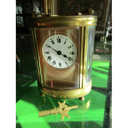 1122 - Oval Form Brass Bound Carriage Clock with Key Attractively Detailed Approximately 5 Inches High