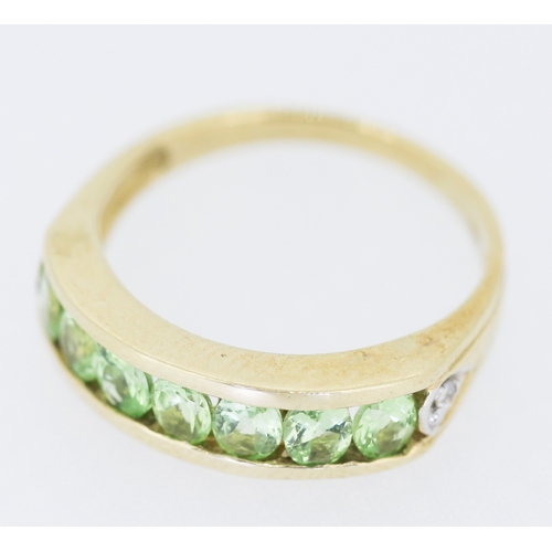 132 - Peridot Seven Stone Ring Channel Set in 9 Carat Yellow Gold Ring Size N