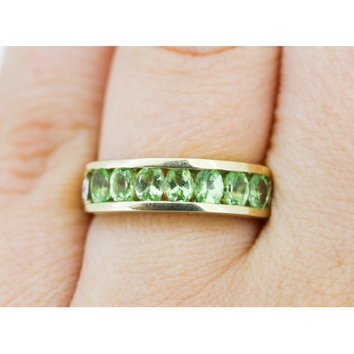 132 - Peridot Seven Stone Ring Channel Set in 9 Carat Yellow Gold Ring Size N