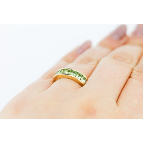 132 - Peridot Seven Stone Ring Channel Set in 9 Carat Yellow Gold Ring Size N