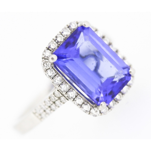 15 - Emerald Cut AAAA Vivid Tanzanite Centre Stone Ring with Diamond Set Halo Surround and Further Diamon... 