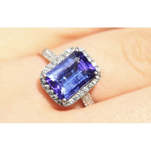 15 - Emerald Cut AAAA Vivid Tanzanite Centre Stone Ring with Diamond Set Halo Surround and Further Diamon... 