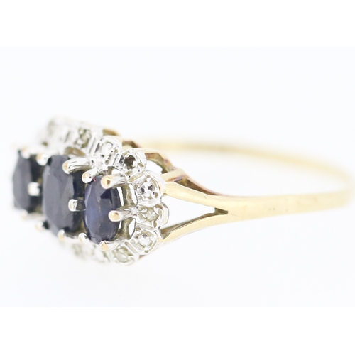 191 - Sapphire Three Stone Ring with Further Diamond Insets Mounted in 9 Carat Yellow Gold Ring Size R