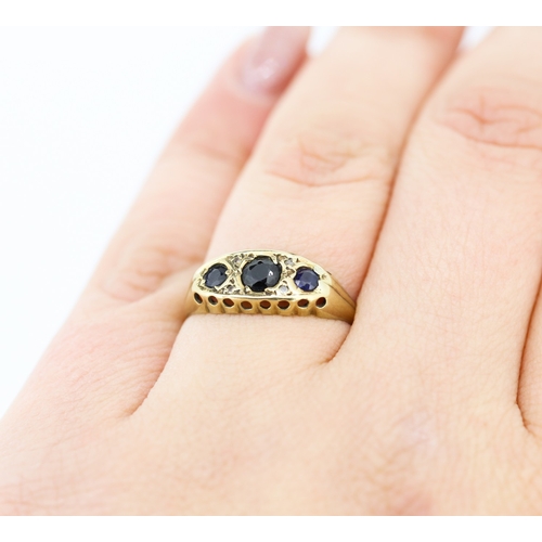 235 - Sapphire Three Stone Ring with Diamond Insets Mounted in 9 Carat Yellow Gold Ring Size N