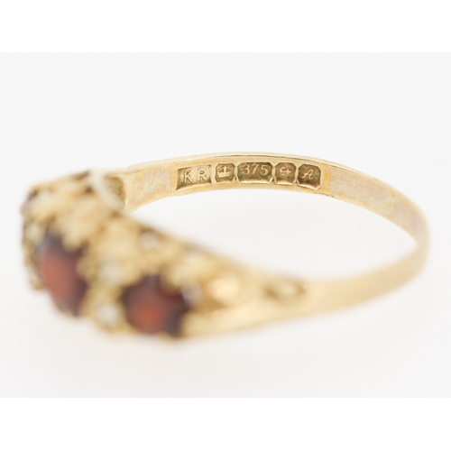 419 - Red Garnet Three Stone Ring with Further Gemstone Insets Mounted in 9 Carat Yellow Gold Ring Size M ... 