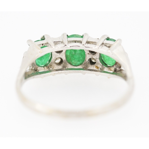 80 - Emerald Three Stone Ring with Diamond Insets Mounted in 18 Carat White Gold Ring Size P and a Half