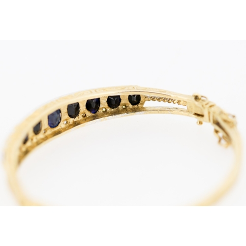 41 - Attractively Detailed Sapphire Nine Stone Set Graduated Form Bangle Bracelet Mounted in 9 Carat Yell... 