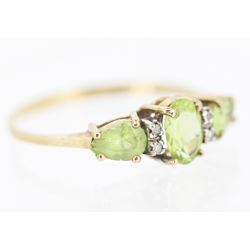 49 - Peridot Set Three Stone Ring with Further Diamond Insets Mounted in 9 Carat Yellow Gold Ring Size T