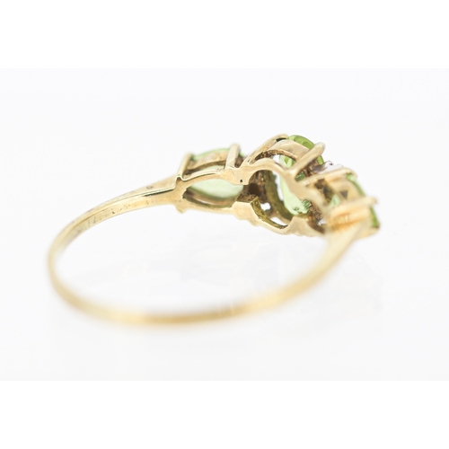 49 - Peridot Set Three Stone Ring with Further Diamond Insets Mounted in 9 Carat Yellow Gold Ring Size T