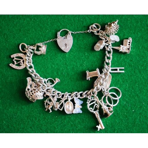 47 - Silver Charm Bracelet Adorned with Various Charms Safety Chain and Padlock Motif Clasp Present