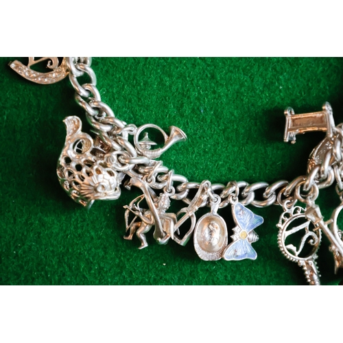 47 - Silver Charm Bracelet Adorned with Various Charms Safety Chain and Padlock Motif Clasp Present