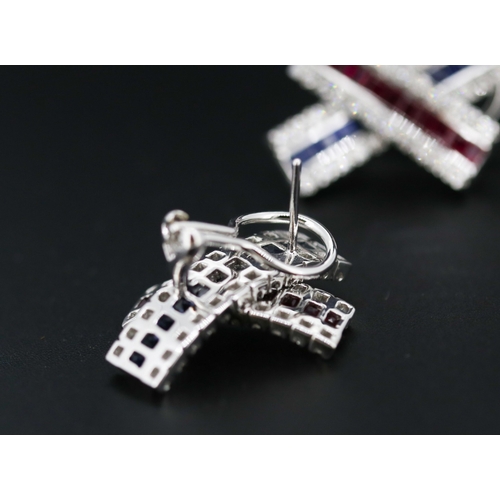 13 - Pair of Attractively Detailed Baguette Cut Ruby, Sapphire and Round Cut Diamond Set Cross Over Earri... 