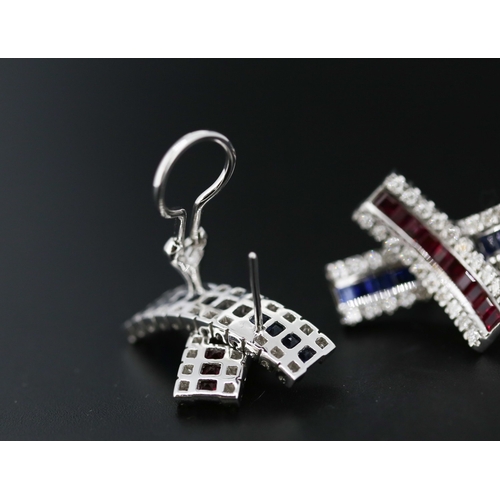 13 - Pair of Attractively Detailed Baguette Cut Ruby, Sapphire and Round Cut Diamond Set Cross Over Earri... 