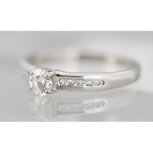 21 - Diamond Solitaire Ring with Further Channel Set Diamonds to Shoulders Mounted in 18 Carat White Gold... 