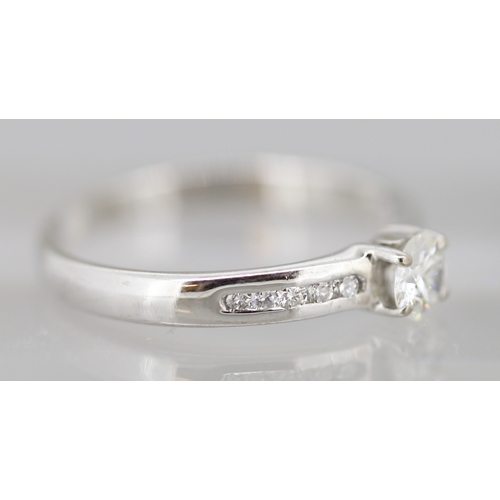 21 - Diamond Solitaire Ring with Further Channel Set Diamonds to Shoulders Mounted in 18 Carat White Gold... 