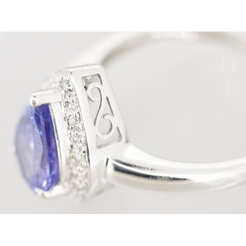 30 - Pear Cut Tanzanite Set Ring with Diamond Set Surround Mounted in 18 Carat White Gold Ring Size P
