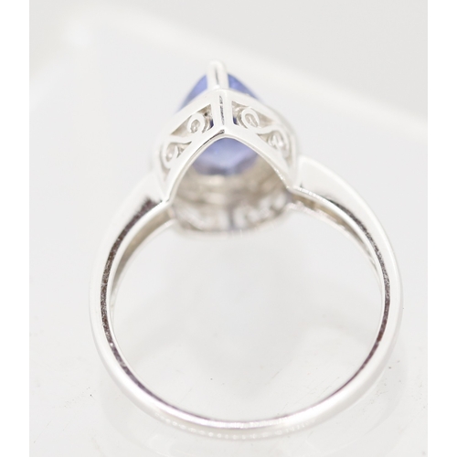 30 - Pear Cut Tanzanite Set Ring with Diamond Set Surround Mounted in 18 Carat White Gold Ring Size P