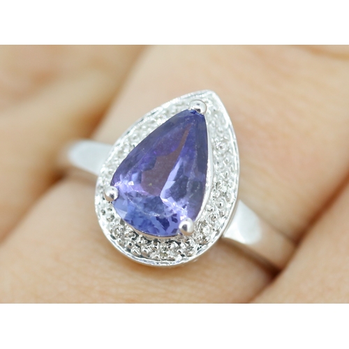 30 - Pear Cut Tanzanite Set Ring with Diamond Set Surround Mounted in 18 Carat White Gold Ring Size P