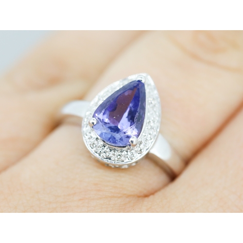 30 - Pear Cut Tanzanite Set Ring with Diamond Set Surround Mounted in 18 Carat White Gold Ring Size P