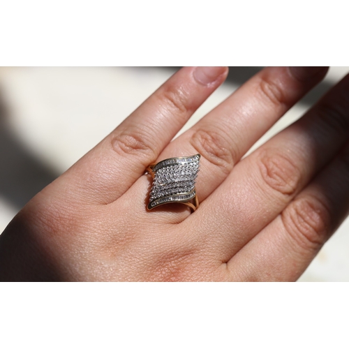 16 - Finely Detailed Round Cut and Tapered Baguette Cut Diamond Set Cluster Ring, Mounted in 9 Carat Yell... 