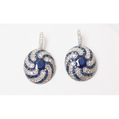 25 - Pair of Finely Detailed Sapphire Centre Stone Set Earrings with Diamond and Sapphire Swirl Motif Set... 