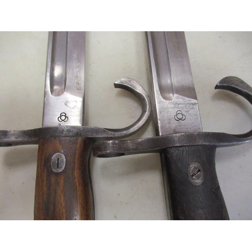 113 - Japanese Arisaka Type 30 bayonets with metal scabbards, both with Tokyo Arsenal maker's mark, pommel... 