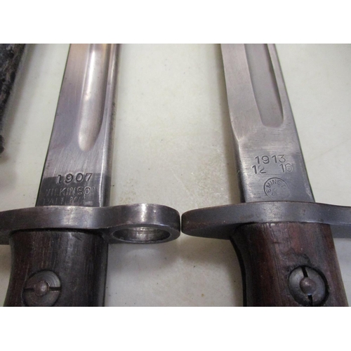 96 - US & GB bayonet and leather scabbard range with:
1. 1942 Wilkinson 1907 Pattern, ricasso marked crow... 