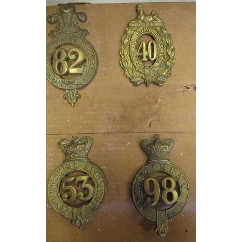 61 - 1874-81 Glengarry badge collection mounted on cardboard with 11th, 12th, 53rd, 59th, 105th, 40th etc... 