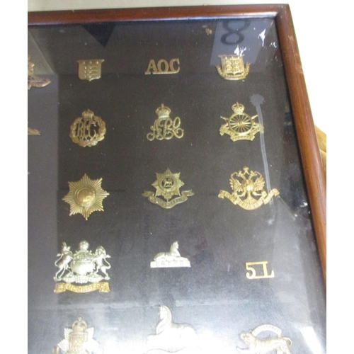 70 - Collection in large wood and glass frame of metal cap badges, shoulder titles etc, including QV 1st ... 