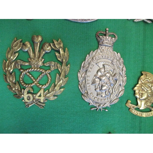 102 - Collection of cap badges with odd arm badge etc mounted on foam board in large wooden frame (91cm x ... 