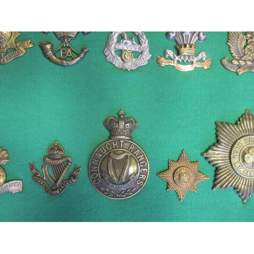 102 - Collection of cap badges with odd arm badge etc mounted on foam board in large wooden frame (91cm x ... 