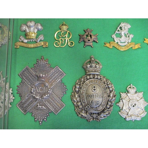 102 - Collection of cap badges with odd arm badge etc mounted on foam board in large wooden frame (91cm x ... 