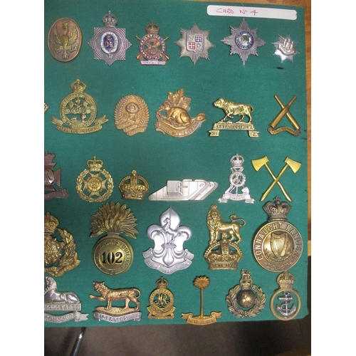 104 - Collection mounted on 2 boards of mostly cap badges, also few arm badges etc including QV Connaught ... 