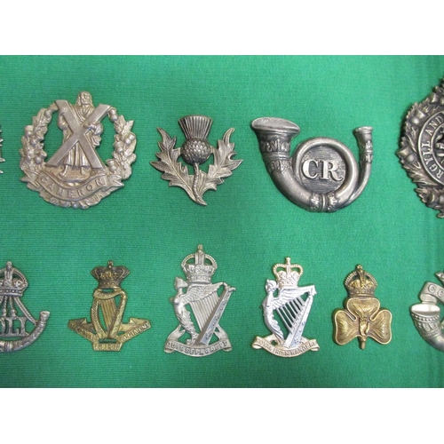 105 - Collection of cap badges with odd arm badge etc mounted on foam board in large wooden frame (91cm x ... 