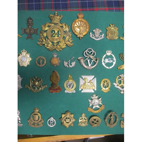 106 - Collection mounted on 3 boards of mostly cap badges, also few arm badges etc including QV 24th Foot,... 