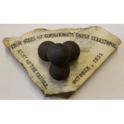 257 - 4 small shrapnel balls (approx 3cm diameter) mounted on a piece of marble inscribed 