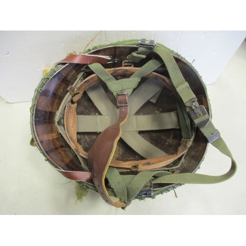 183 - U.S. Paratrooper's M-1 helmet and liner, green textured painted shell, A strap with leather chincup,... 