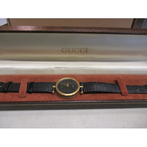 423 - Gucci unisex wrist watch, 30mm dial, gold coloured case, black dial with no numerals, Gucci, logo an... 