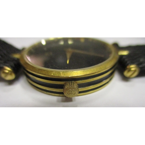 423 - Gucci unisex wrist watch, 30mm dial, gold coloured case, black dial with no numerals, Gucci, logo an... 