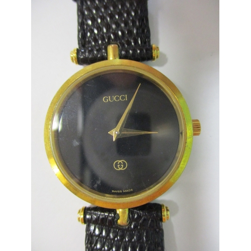 423 - Gucci unisex wrist watch, 30mm dial, gold coloured case, black dial with no numerals, Gucci, logo an... 