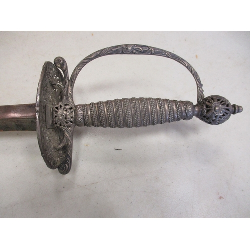 107 - 18th Century silver hilted small sword and scabbard, pierced shell guard with ornate trophy of arms ... 