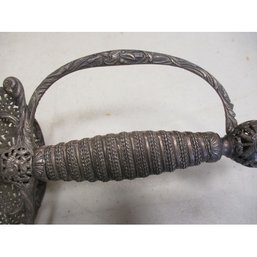 107 - 18th Century silver hilted small sword and scabbard, pierced shell guard with ornate trophy of arms ... 