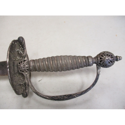 107 - 18th Century silver hilted small sword and scabbard, pierced shell guard with ornate trophy of arms ... 