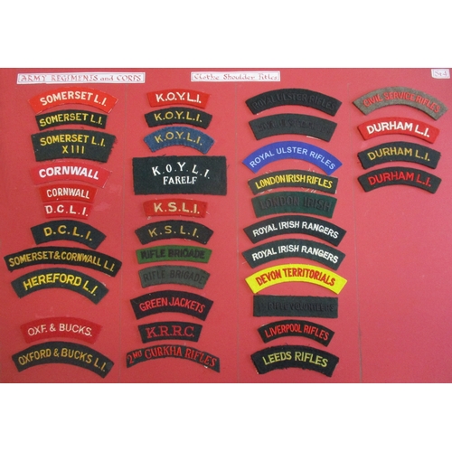 184 - Cloth shoulder title collection mounted on 2 boards with double sided tape. Mainly embroidered lette... 